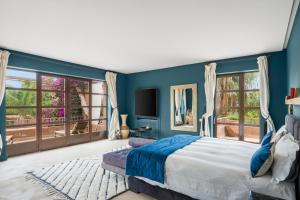 a bedroom with blue walls and a bed and windows at Villa Socar - Heated pool - Padel - Marrakech in Najem +100 photos