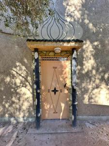 a door with a bow and arrow on it at Écolodge OASIS Vallée du ZIZ Gîte DAR UL in Maarka