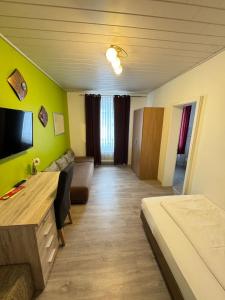 salon z kanapą i telewizorem w pokoju w obiekcie Hotel Brigach w mieście Villingen-Schwenningen