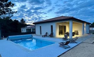 a swimming pool with chairs and a house at Villa Dyane in Salavas