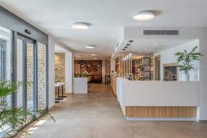 a lobby with a white counter and plants at Park Hotel Faver in Tremosine Sul Garda +112 photos