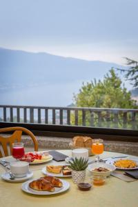 a table with breakfast food on a balcony at Park Hotel Faver in Tremosine Sul Garda