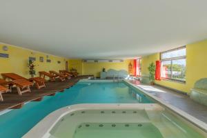 a pool in a hotel with tables and chairs at Park Hotel Faver in Tremosine Sul Garda