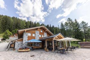 a building with tables and chairs in front of it at Hotel Chalet Serena in Roncegno