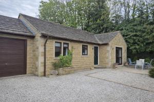 a small brick house with a garage at Large 2-Bedroom Bungalow near Airedale Hospital, Keighley, Convenient Location with Parking in Steeton