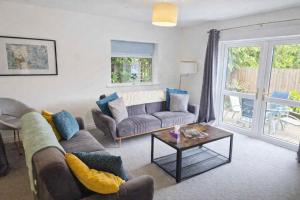 a living room with a couch and a table at Large 2-Bedroom Bungalow near Airedale Hospital, Keighley, Convenient Location with Parking in Steeton +6 photos