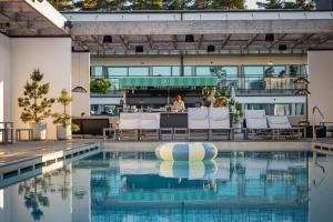 a pool at a hotel with chairs and a bar at Hotel Riviera Strand in Båstad +57 photos