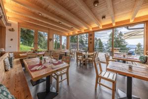 a restaurant with wooden tables and chairs and windows at Hotel Chalet Serena in Roncegno