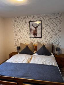 a bedroom with a bed with a deer on the wall at Ferienhaus Kaline in Grebenhain