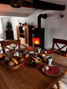 a wooden table with food and a fireplace in a room at Ferienhaus Kaline in Grebenhain