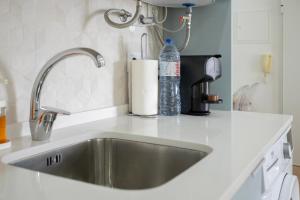 a kitchen sink with a bottle of water on it at Centralgarve - Amazing Apt in the Heart of Vilamoura in Vilamoura +33 photos