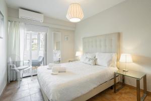 a bedroom with a large white bed and a table at Centralgarve - Amazing Apt in the Heart of Vilamoura in Vilamoura