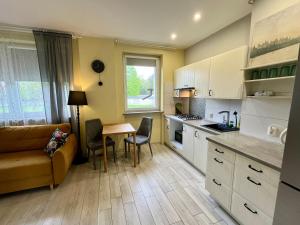 a kitchen and living room with a couch and a table at Apartament COMFORT Centrum in Krotoszyn