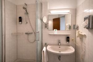 a bathroom with a shower and a sink and a shower at Stadthotel Jülich in Jülich