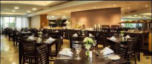 a restaurant with tables and chairs and a bar at 1601 - Hotel & Residence Sol Alphaville Flat in Barueri