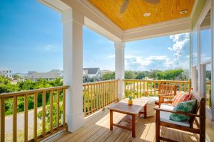 a screened porch with a table and chairs on a deck at All Sands On Deck by Oak Island Accommodations in Oak Island