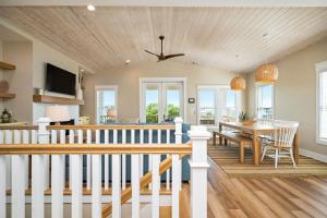 a dining room and living room with a table and a ceiling at All Sands On Deck by Oak Island Accommodations in Oak Island