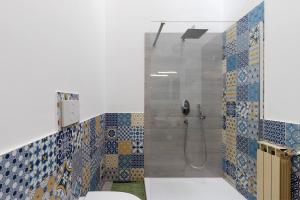 a bathroom with a shower with blue and white tiles at Casa Vacanze Bouganvillea in Sabaudia +19 photos