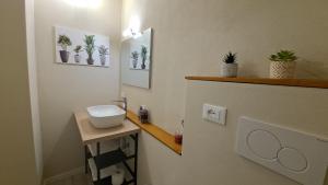 a bathroom with a sink and some plants on the wall at Monte Ricco Appartamenti in Monselice