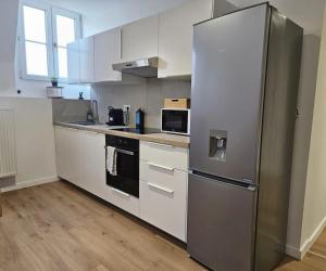 a kitchen with a stainless steel refrigerator and white cabinets at Atomium Apartment 2 in Brussels