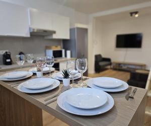 a wooden table with plates and wine glasses on it at Atomium Apartment 2 in Brussels +15 photos