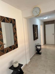 a hallway with a mirror and a clock on the wall at Къща Елена in Yagoda +56 photos