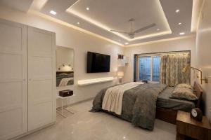 a bedroom with a bed and a tv on the wall at Pet Friendly Spacious 3 BHK Penthouse in Mumbai