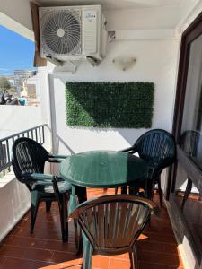 a green table and chairs on a balcony at Apartamento Oura - Albufeira in Bicas