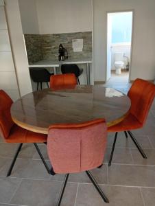 a dining room with a table and orange chairs at Le logis de la liane in Boulogne-sur-Mer
