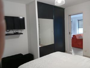 a bedroom with a bed and a tv on a wall at Le logis de la liane in Boulogne-sur-Mer