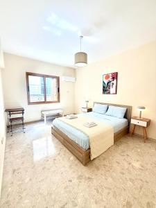 a bedroom with a large bed and a table at Latchi Marina in Lachi +22 photos