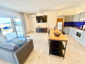 a living room with a couch and a table at Latchi Marina in Lachi