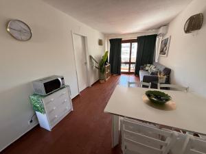a living room with a kitchen and a microwave at Apartamento Oura - Albufeira in Bicas