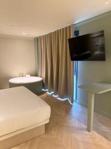 a room with a bed and a tv and a table at AT Boutique Alma in Alicante