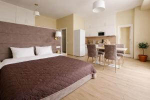 a bedroom with a large bed and a kitchen at Five Seasons apartments in Odesa +136 photos