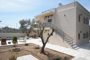 a building with a tree in front of it at Villa Noema Kineta in Kineta