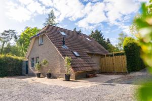 a brick house with windows and a fence at Luxe wellnesshuis op de Veluwe in Lunteren