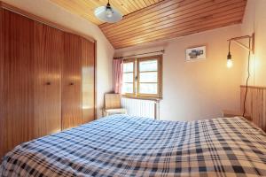 a bedroom with a bed with a blue plaid blanket at Gîte de la Séoube in Campan