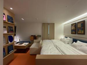 a bedroom with a large white bed and a desk at Hotel Inspiroom Jongro in Seoul