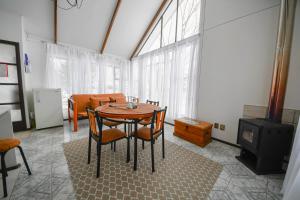 a dining room with a table and chairs and a tv at Cabañas Terravento in Puerto Natales