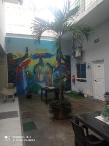 a palm tree in a room with a mural at Mi Quinta Raíz Loft Apartments in Iquitos