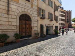 Un gruppo di persone che camminano lungo una strada accanto a un edificio di Residenza Maritti Classic Rooms a Roma