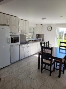 a kitchen with a table and chairs and a clock at Yellow house in Skene
