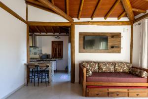 a living room with a couch and a kitchen at Siriúba Reserve in Ilhabela