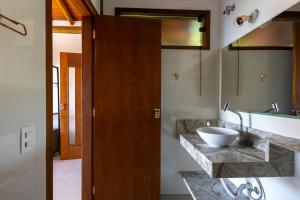 a bathroom with a sink and a mirror at Siriúba Reserve in Ilhabela +43 photos