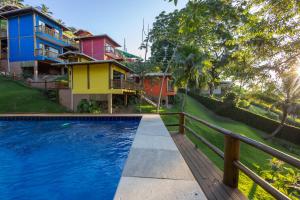 a pool in front of a house with a fence at Siriúba Reserve in Ilhabela