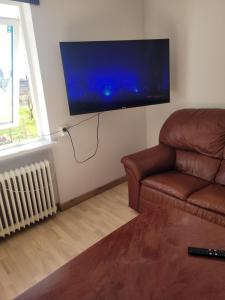 a living room with a couch and a flat screen tv at Yellow house in Skene