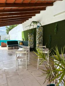 a patio with chairs and tables and a green wall at Coruche Pool & Jacuzzi Residence - Condomínio Privado in Coruche