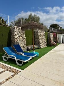 two lounge chairs and an umbrella in a yard at Coruche Pool & Jacuzzi Residence - Condomínio Privado in Coruche