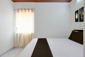 a bedroom with a bed and a window at Srinivasa Hotel in Narasingāpuram